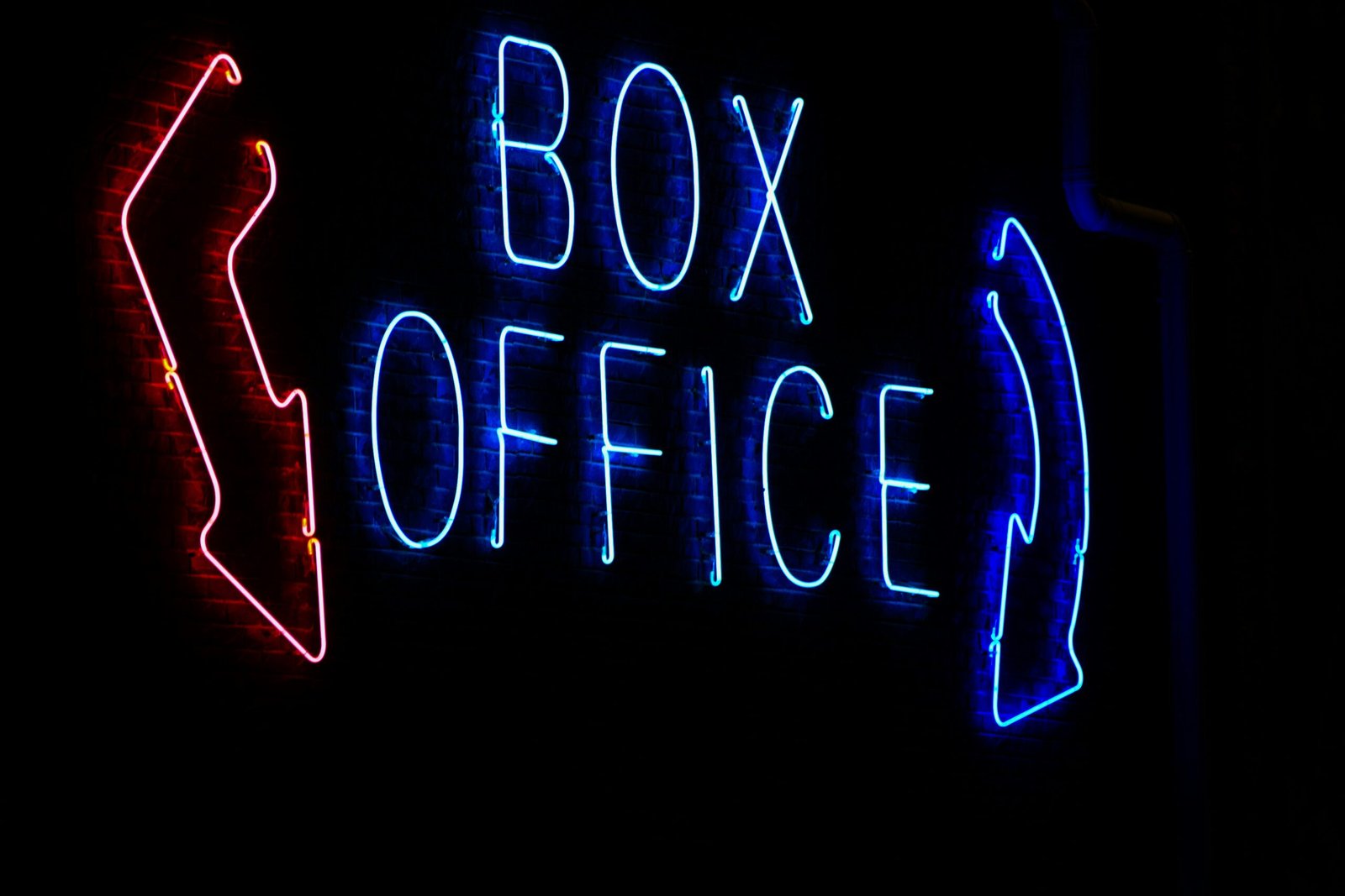 a box office sign lit up in the dark